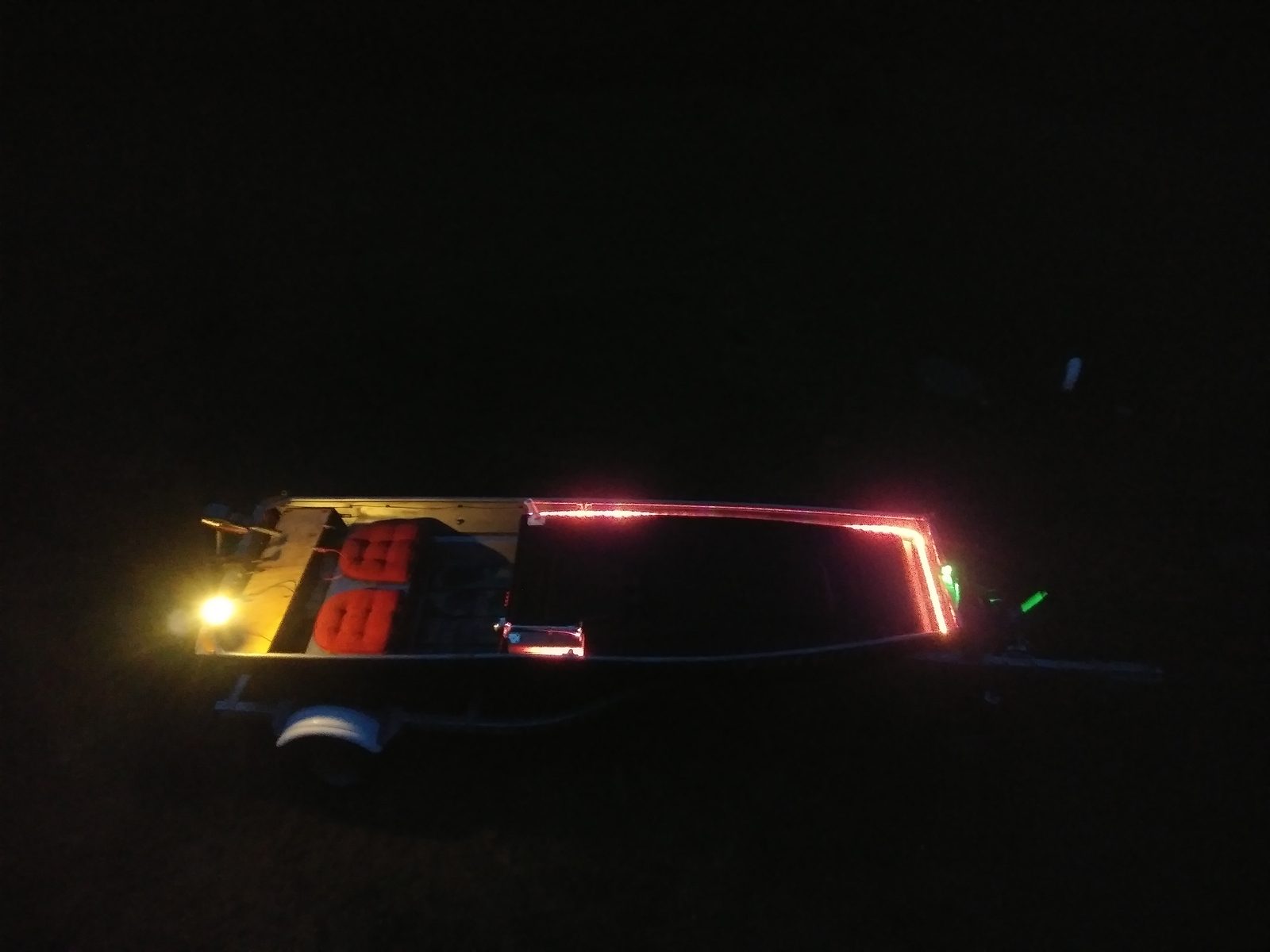 Night shot of red LED strip lighting up the boat's frame